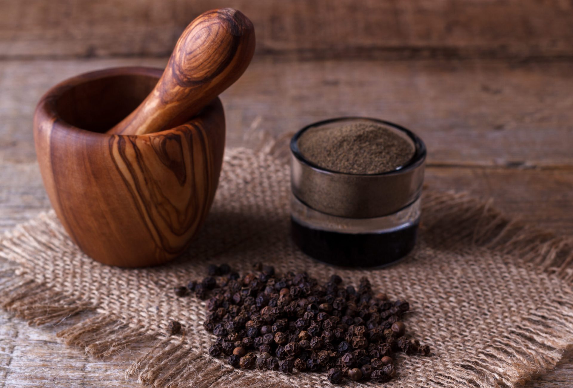 Black pepper corns and Black pepper Powder on wooden background